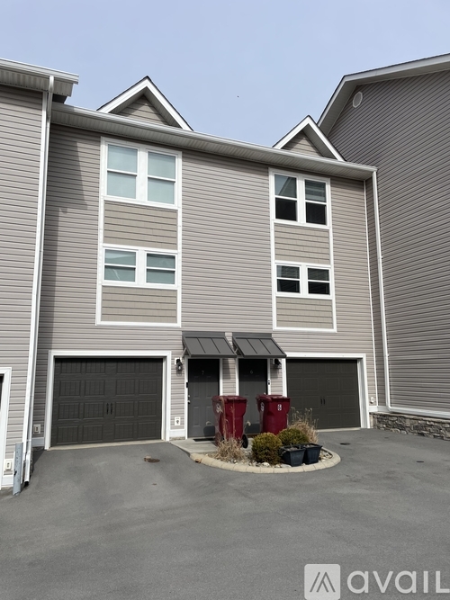 A two-story house with a garage and a small front yard.
