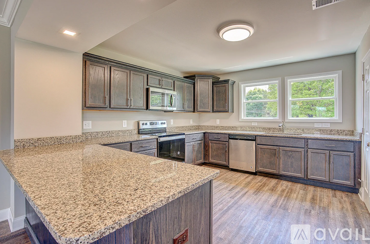 A kitchen with granite countertops and wooden cabinets.