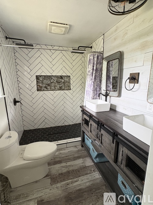 A bathroom with a white toilet and a wooden vanity.