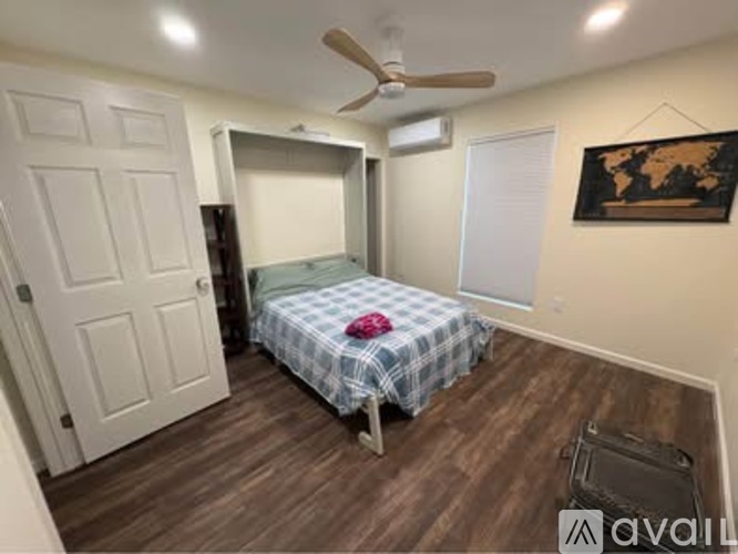 A bedroom with a bed, dresser, and a ceiling fan.