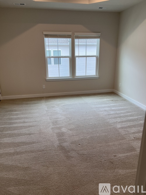 A room with a carpeted floor and a window.