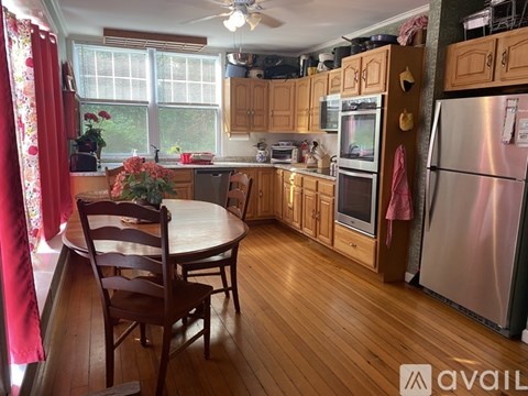 A kitchen with wooden floors and a table with chairs.