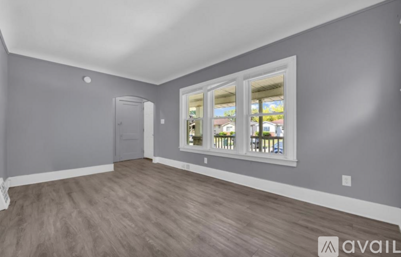 A room with grey walls and a window with a view of a street.
