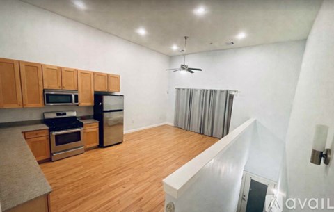 A kitchen with wooden cabinets and a stainless steel refrigerator.