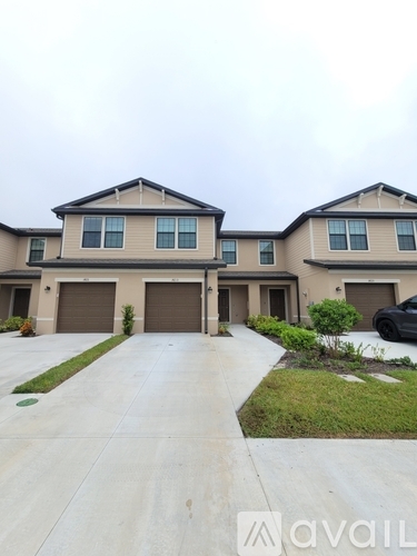 A two-story house with a driveway in front.