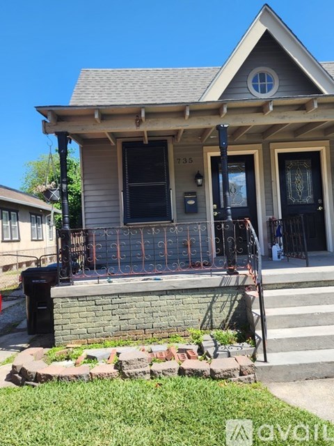 A house with a front porch and a black door.