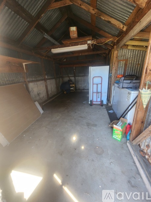 A room with a corrugated metal roof and a white door.