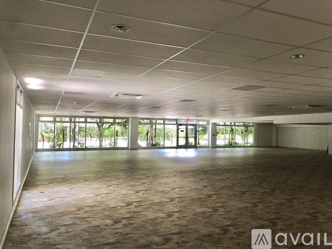 A spacious room with a large window and a sign that says "AVAIL".