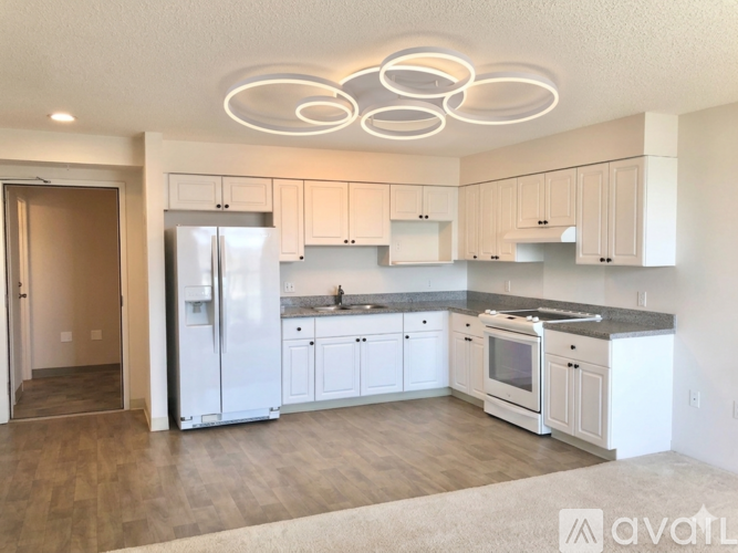A kitchen with white cabinets and a refrigerator.