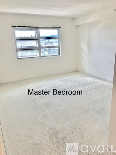 A master bedroom with a window overlooking a snowy landscape.