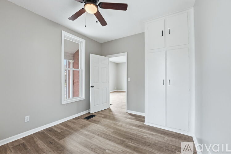 A room with a ceiling fan and wooden flooring.