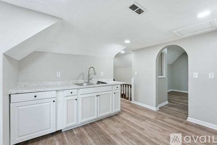 A kitchen with white cabinets and a marble countertop.