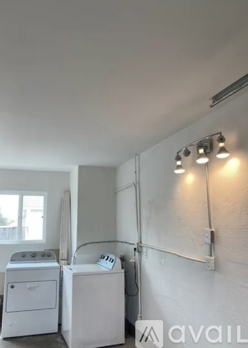 A small laundry room with a washer and dryer.