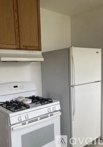 A white stove and a white refrigerator in a kitchen.