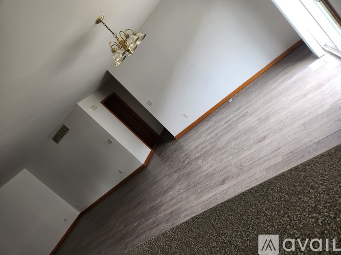 A room with a grey carpet and a chandelier.