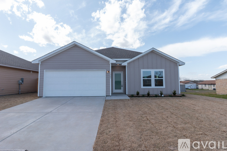 A house with a garage and a driveway is available for sale.
