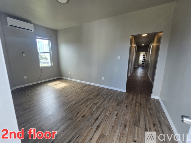 A room with wooden flooring and a window on the wall.