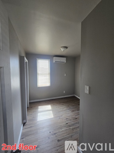 A room with a window and wooden flooring on the second floor.