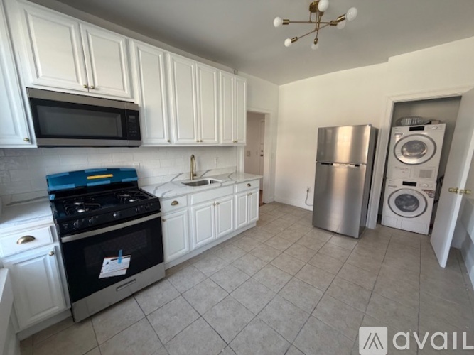 A kitchen with white cabinets and a black stove top.
