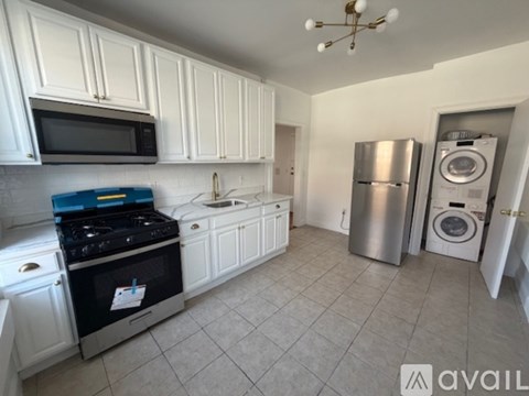 A kitchen with white cabinets and a black stove top.