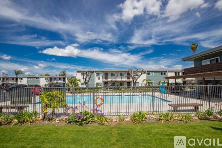 A pool surrounded by a fence and a few trees.