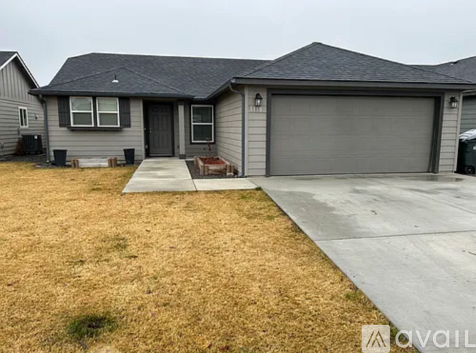 A house with a grey garage door is available for sale.
