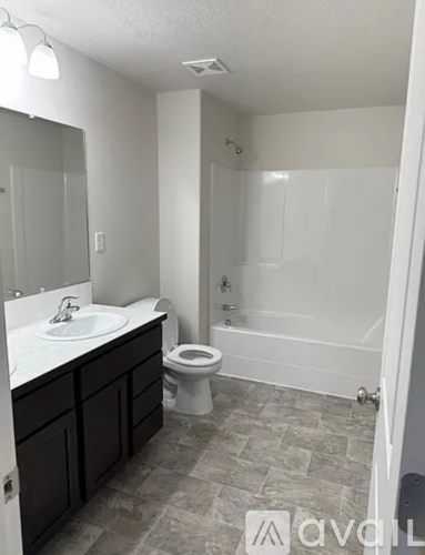 A bathroom with a toilet, sink, and bathtub.