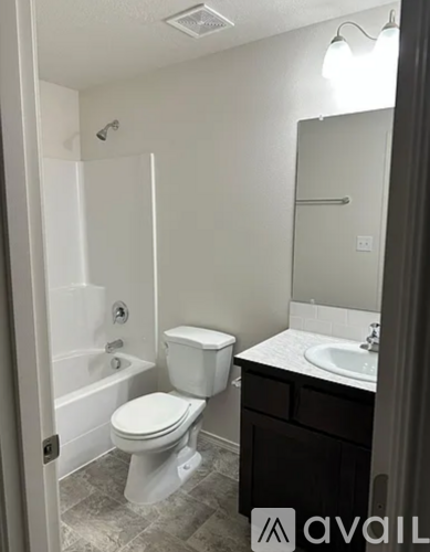 A bathroom with a toilet, sink, and bathtub.