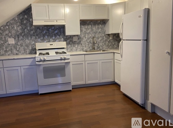 A kitchen with white appliances and cabinets.