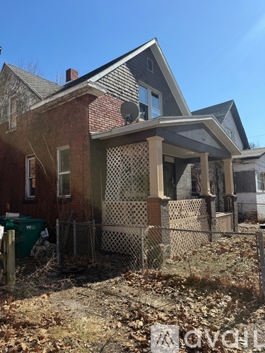 A house with a red brick exterior and a white fence.