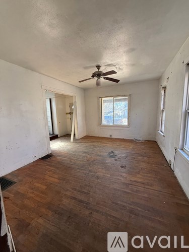 A room with wooden floors and a ceiling fan.