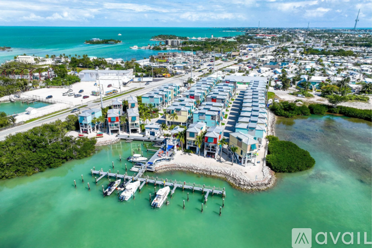 A marina with boats docked in the water and buildings in the background.