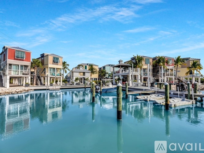 A row of modern houses are built on stilts over a body of water.