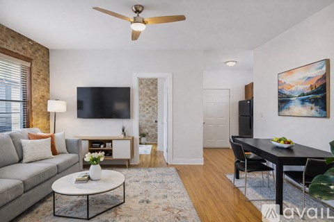 A living room with a grey couch, a coffee table, a flat screen TV, and a painting on the wall.