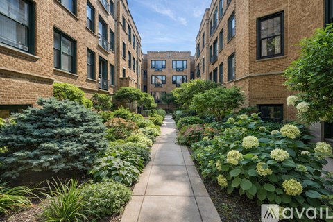 A pathway leads through a landscaped courtyard between two rows of buildings.