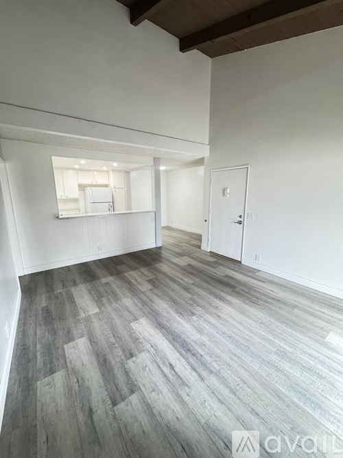 A room with wooden flooring and white walls.