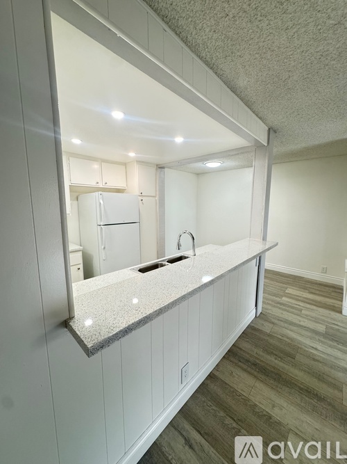 A kitchen with a granite countertop and a refrigerator.