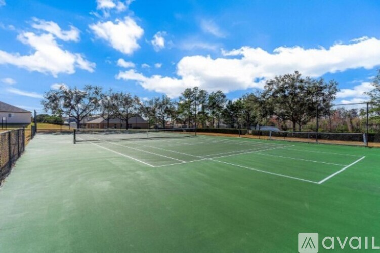 A tennis court with a net and trees in the background.