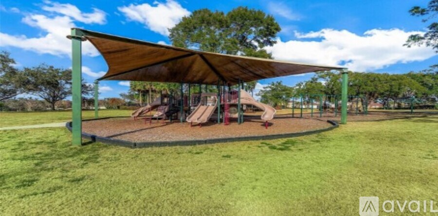 A playground with a swing set and a canopy.