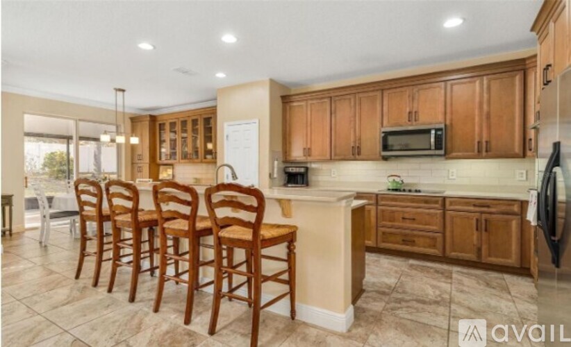 A kitchen with wooden chairs and cabinets.
