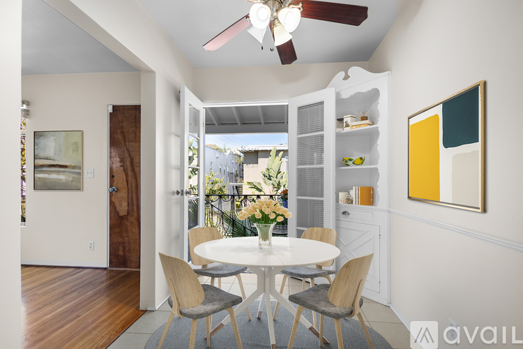 A dining room with a white table and chairs.
