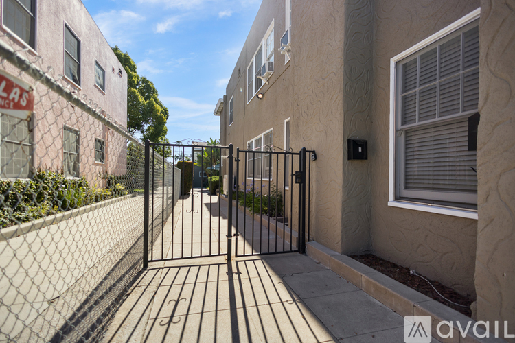 A black gate blocks the entrance to a driveway.