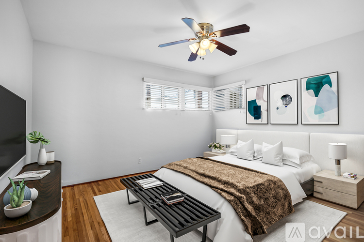 A bedroom with a bed, nightstand, and a ceiling fan.