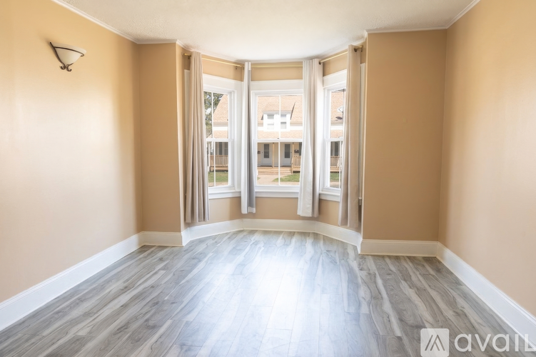 A room with a wooden floor and a wall-mounted light fixture.
