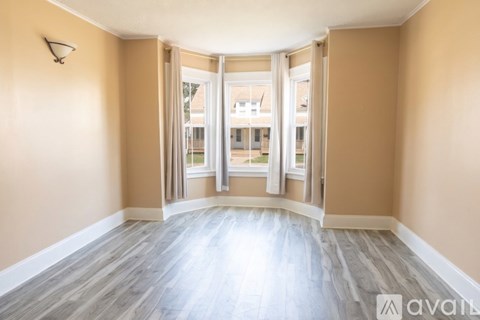 A room with a wooden floor and a wall-mounted light fixture.