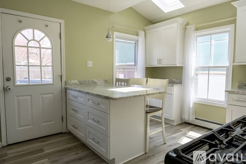 A kitchen with a white countertop and cabinets.