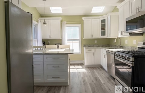 A kitchen with a white countertop and cabinets.
