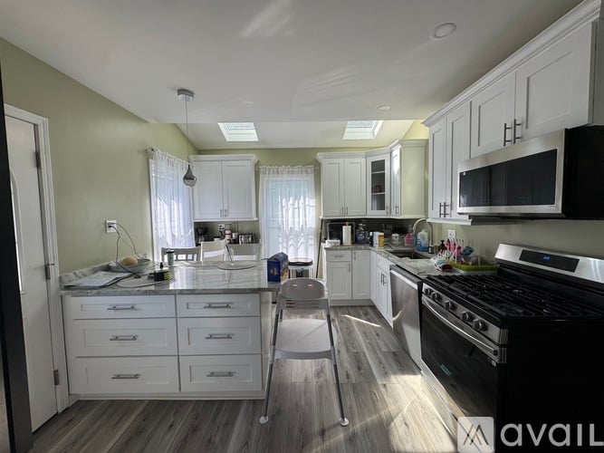 A kitchen with white cabinets and a black stove top oven.