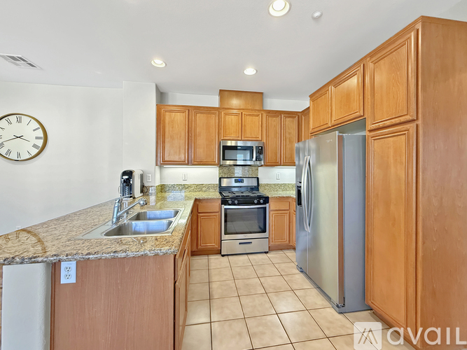 A kitchen with wooden cabinets and a granite countertop.