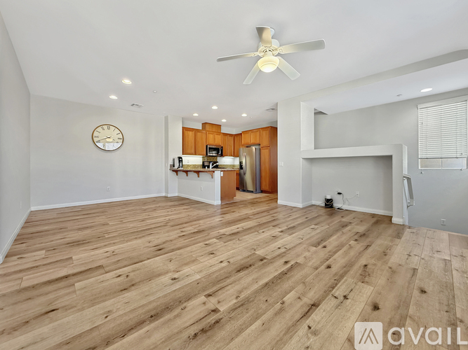 A spacious room with wooden flooring and a ceiling fan.
